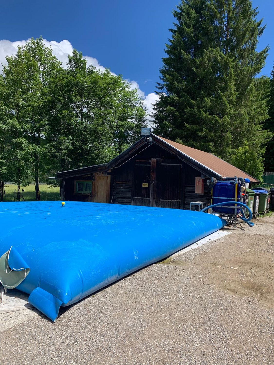 MTDs potable water tank and buffer bag in front of a cabin in nature
